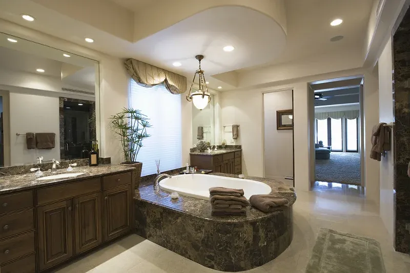 Spacious bathroom with a bathtub mirrors and dark wood Spacious bathroom with a bathtub, mirrors, and dark wood